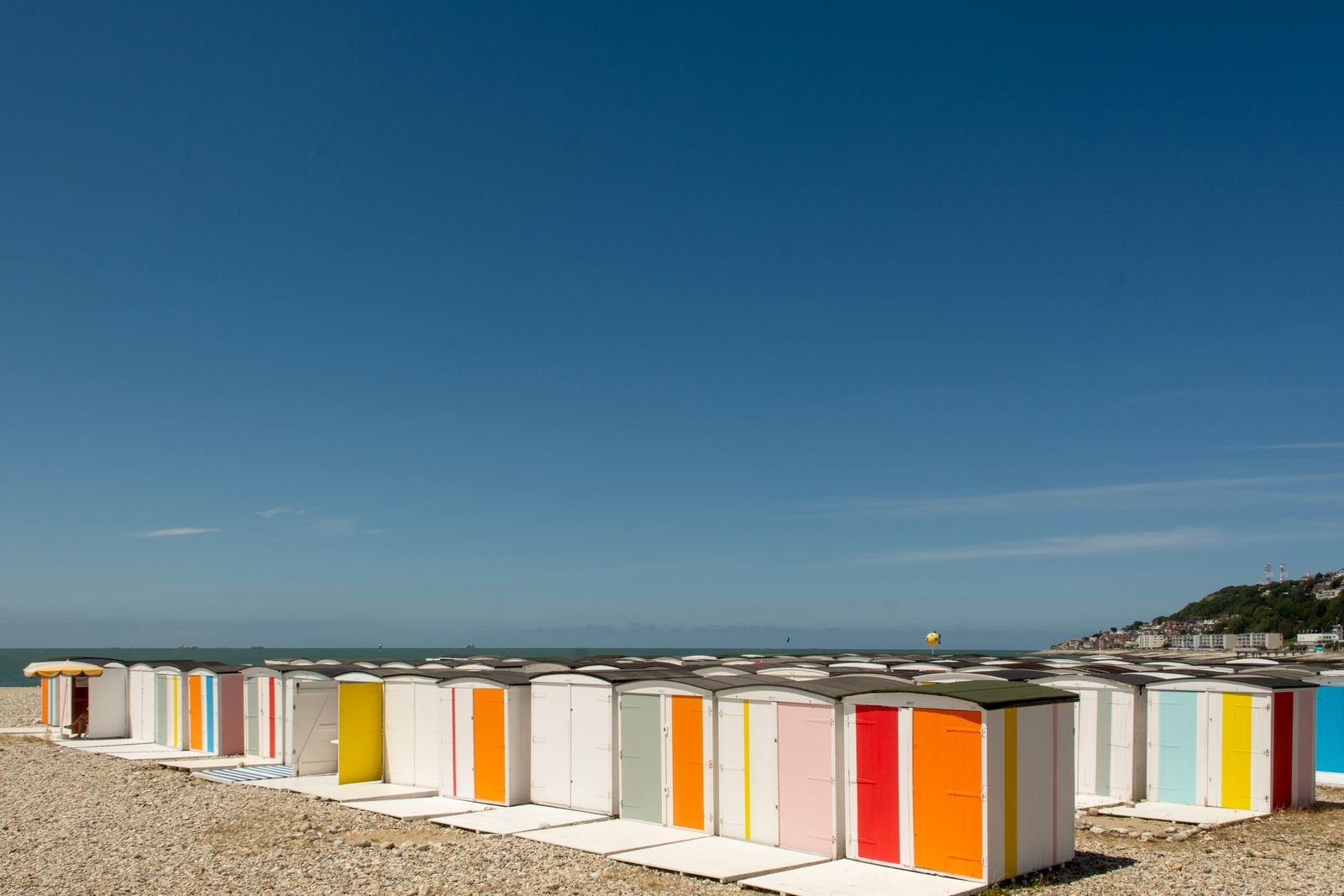 Littoral normand — cabines de plage Cabines de plage colorées alignées sur les galets d'une plage normande.